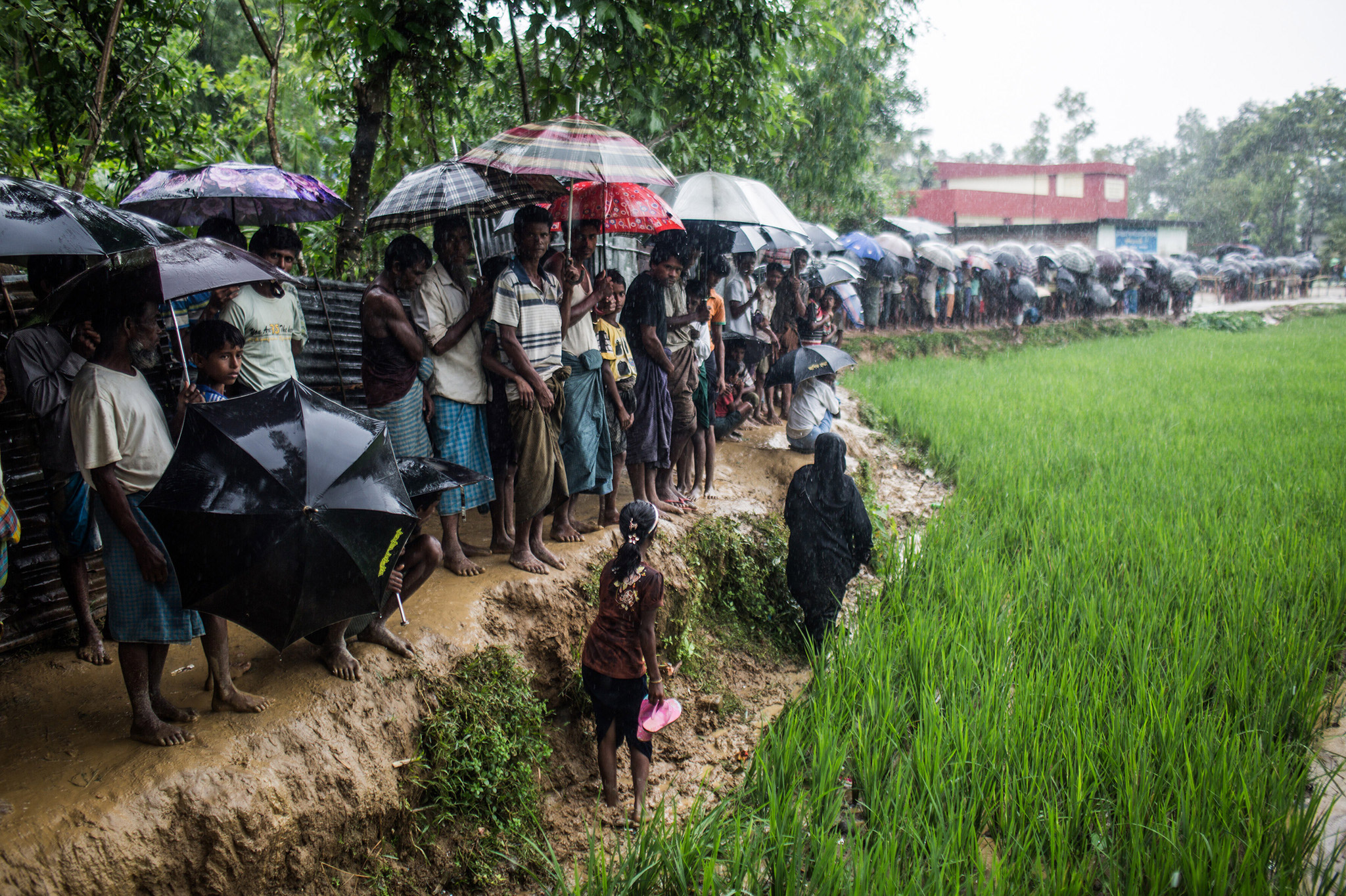 Humanitäre Katastrophe in Myanmar - Rohingya Flüchtlinge warten im Regen auf Hilfslieferungen.